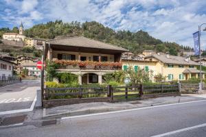 uma casa ao lado de uma rua com uma cerca em Casa Delmarco em Castello di Fiemme