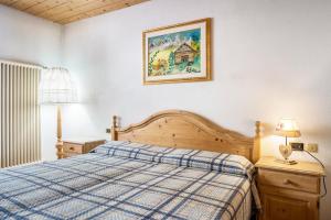um quarto com uma cama e uma fotografia na parede em Casa Delmarco em Castello di Fiemme