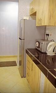 eine Küche mit einem Kühlschrank und einer Mikrowelle in der Unterkunft One Bedroom BnB in Thika Town7 in Thika