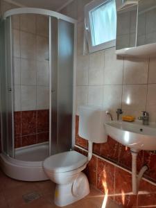a bathroom with a toilet and a sink and a shower at Apartments Beach Way in Trpanj