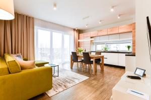 a living room with a yellow couch and a table at Apartamenty Tespis - Francuska Atal Park II in Katowice