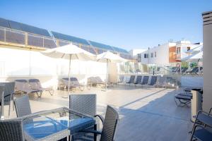 Un patio al aire libre con mesas, sillas y sombrillas. en Porcel Ganivet, en Madrid