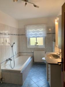 een badkamer met een bad, een toilet en een wastafel bij Ferienwohnung Stadlmann in St. Wolfgang