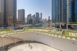 a walkway in a city with a river and buildings at Frank Porter - Continental Tower in Dubai