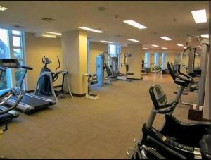 a gym with several treadmills and cardio machines at 2BR El Royale Apartement Braga in Bandung