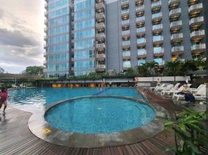 a large swimming pool in front of a building at 2BR El Royale Apartement Braga in Bandung