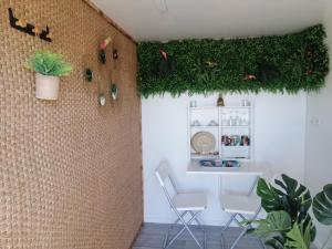 Zimmer mit 2 Stühlen und einer Wand mit Pflanzen in der Unterkunft Tiny house cosy in Anduze