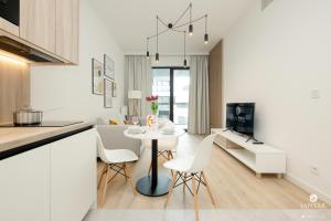 a kitchen and living room with a table and chairs at Shellter Apartments Villas - by Jantar Apartamenty in Rogowo