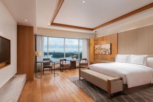 um quarto com uma cama, uma escrivaninha e uma televisão em Melia Yangon em Yangon