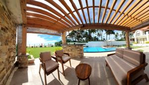 a patio with a wooden pergola and a pool at Aryan Beach Villa in Wadduwa