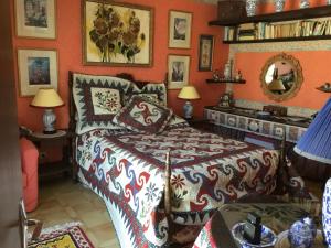 1 dormitorio con 1 cama en una habitación con paredes de color naranja en Villa La Cerisaie en Céret