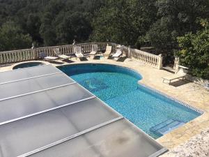 a swimming pool with lounge chairs next to a fence at Villa La Cerisaie in Céret