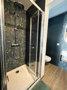 La salle de bains est pourvue d'une douche avec une porte en verre. dans l'établissement Studio le petit écureuil, à Carnac