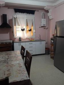 eine Küche mit einem Tisch mit Stühlen und einem Kühlschrank in der Unterkunft au bord de la mer in Alger