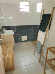 ein Bad mit einem Waschbecken und einer Leiter in der Unterkunft Villa cosy toute équipée avec piscine in Le Gosier