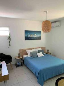 1 dormitorio con 1 cama azul en una habitación en Villa cosy toute équipée avec piscine, en Le Gosier