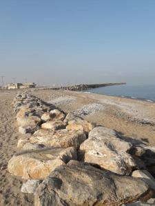 eine Reihe von Felsen an einem Strand neben dem Wasser in der Unterkunft au bord de la mer in Alger