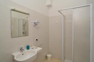 La salle de bains blanche est pourvue d'un lavabo et d'une douche. dans l'établissement VILLARTE, à Agliana