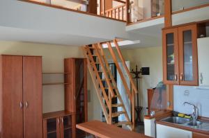 a kitchen with wooden stairs leading up to a loft at Apartments Zlatko Delic in Ika
