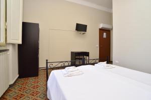 Cette chambre comprend un lit avec un drap blanc et un écran. dans l'établissement VILLARTE, à Agliana