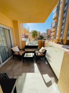 a balcony with chairs and a couch on a building at EMbers La Manga in San Blas