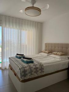 a bedroom with a large bed and a window at EMbers La Manga in San Blas