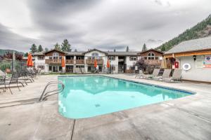 einen Pool in einem Resort mit Tischen und Stühlen in der Unterkunft Icicle Village Resort 507: Alpenglow Condo in Leavenworth