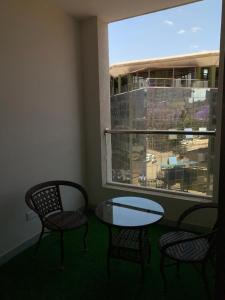 a room with two chairs and a table and a window at 1-BR Gem Near GTC, Westlands 5G in Nairobi