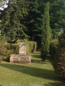 een tuin met een stenen monument in het gras bij Gite 2 pers. Au Pied Du Vercors in Vinay