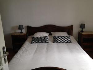 een slaapkamer met een bed met 2 kussens erop bij Gite 2 pers. Au Pied Du Vercors in Vinay