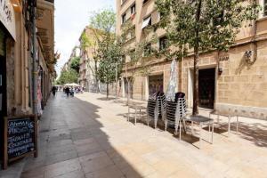 a street with tables and chairs on a sidewalk at Apartament modern al carrer Blai, Poble Sec in Barcelona
