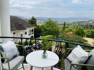a white table and chairs on a balcony with a view at White villa apartment in Kigali