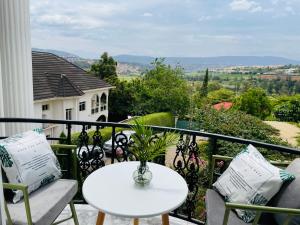 una mesa blanca y sillas en un balcón con vistas en White villa apartment en Kigali