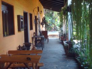 a patio with benches and tables in a building at Hotel Villa Santo Domingo in Concepción de Ataco