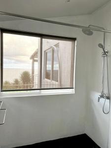 a bathroom with a window with a view of the ocean at Cloud 11 Jamaica in Treasure Beach