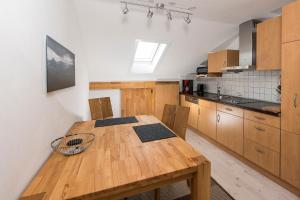 a kitchen with a wooden table and wooden cabinets at Ferienwohnung Kupfer in Sonthofen