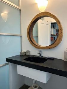 La salle de bains est pourvue d'un lavabo noir et d'un miroir. dans l'établissement Cloud 11 Jamaica, à Treasure Beach