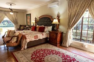 a bedroom with a bed and a chair and windows at Hidden Grace in Parys +49 photos