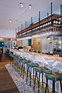 a bar with green stools in a restaurant at Clubhaus Bachmair Weissach in Tegernsee
