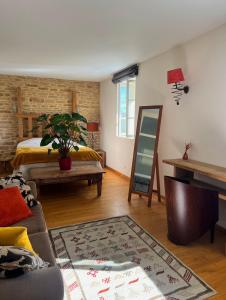 een woonkamer met een bed en een tafel bij La côte des Blancs - Domaine viticole & maison d'hôtes in Vinzelles
