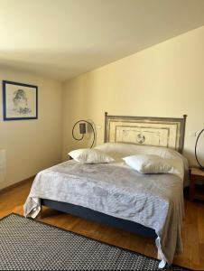 een slaapkamer met een bed met 2 kussens erop bij La côte des Blancs - Domaine viticole & maison d'hôtes in Vinzelles