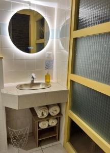 a bathroom with a sink and a mirror and towels at La côte des Blancs - Domaine viticole & maison d'hôtes in Vinzelles