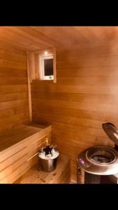 a small bathroom with a toilet and a tub at Northern Lights exclusive house by the river in Boden