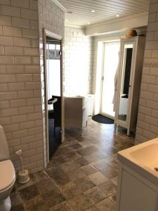 uma casa de banho com um WC, um lavatório e um espelho. em Northern Lights exclusive house by the river em Boden