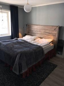 a bedroom with a large bed with a wooden headboard at Northern Lights exclusive house by the river in Boden