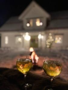 two glasses of wine sitting on top of a table at Northern Lights exclusive house by the river in Boden