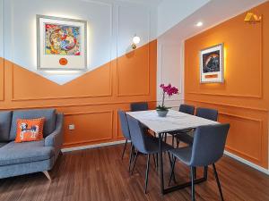comedor con paredes de color naranja, mesa y sillas en SUNWAY•VELOCITY•LUXURY HOUSE 2BR•2-4PAX•KL-TRX-IK, en Kuala Lumpur