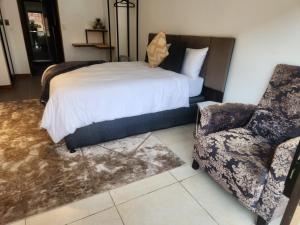 1 dormitorio con 1 cama y 1 silla en 17 On Buffalo, en Johannesburgo
