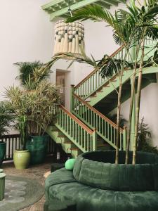 a living room with a staircase and a green couch at Hotel Cesar Lanzarote in La Asomada