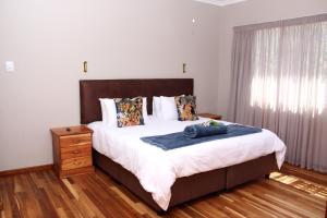 a bedroom with a large bed and a window at Fairy Knowe Hotel in Wilderness +57 photos